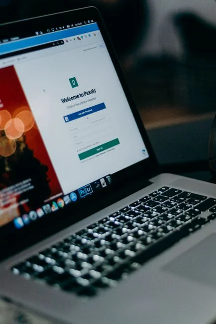 Woman using smartphone for online shopping with credit card in hand, festive background lighting.