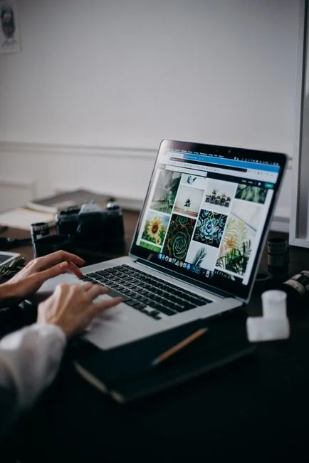 Two people browsing online clothing store on a laptop from above.